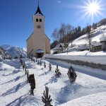 Tief verschneit zeigt sich der Friedhof rund um die Hüttschlager Kirche