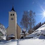 Die Pfarrkirche von Hüttschlag, geweiht dem hl. Josef, links im Bild ein riesiger Eisfall