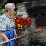 Marianne holt das fertige Brot aus dem Steinofen